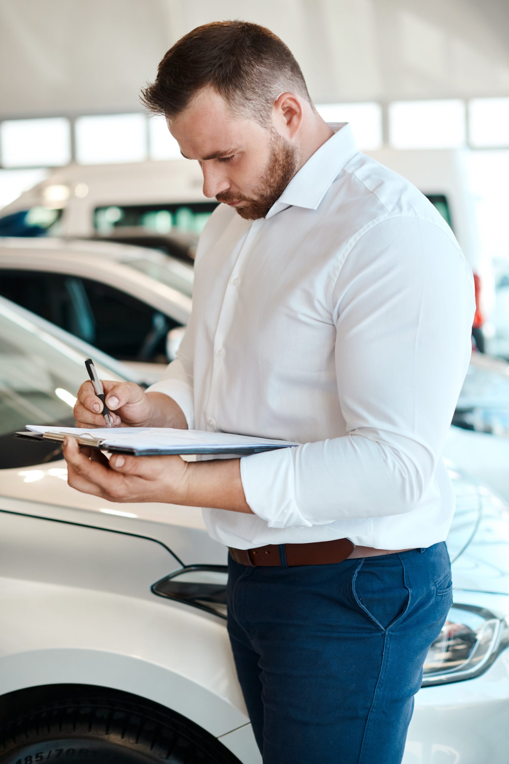 Car dealership, writing or salesman with documents for vehicle, finance checklist or loan paperwork. Insurance, clipboard or seller in showroom with business, transportation or contract by automobile.